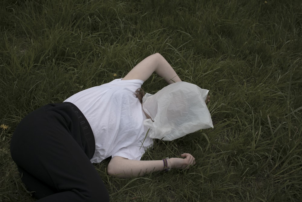 woman lying on grass during daytime