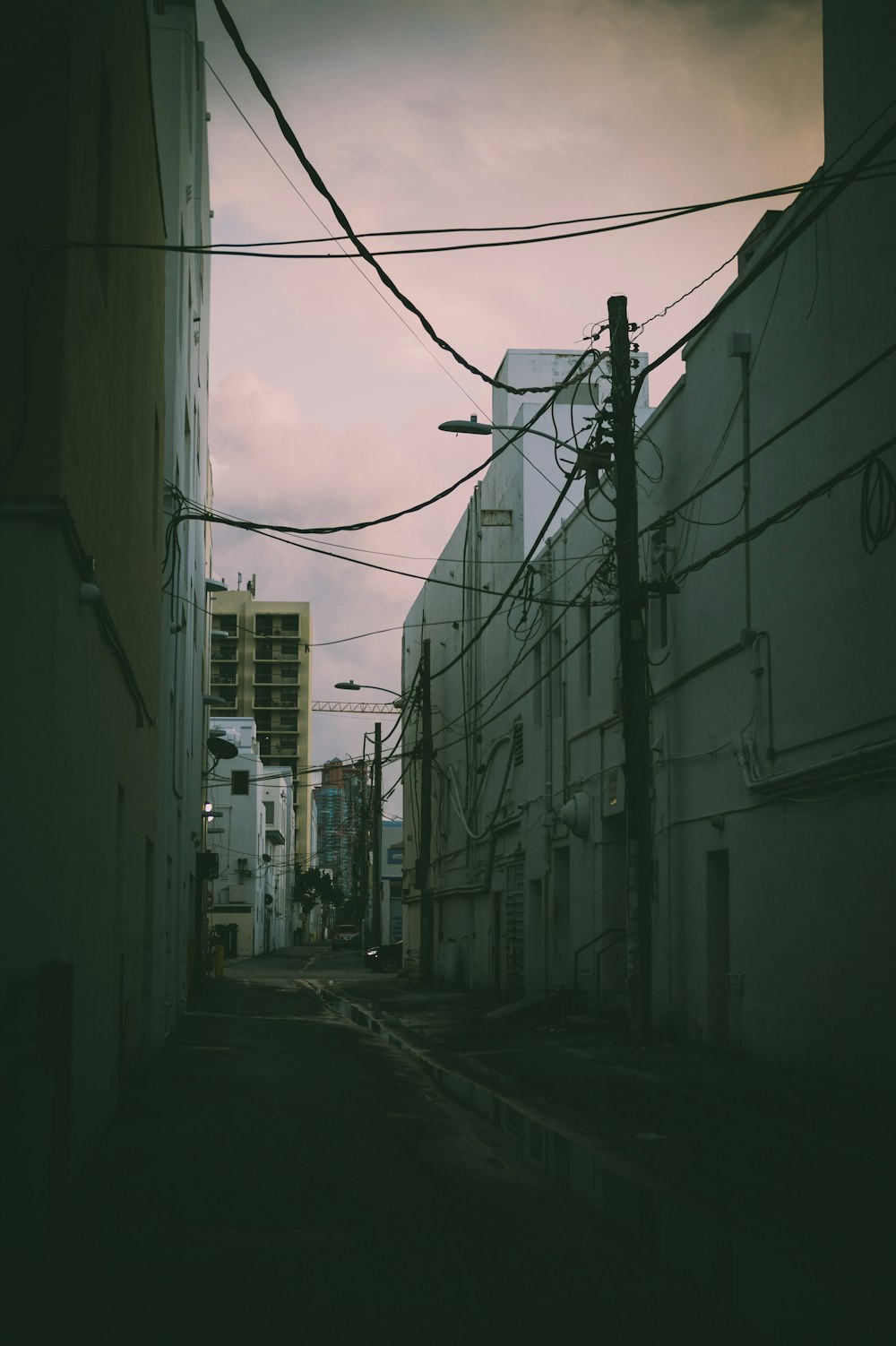 a dark alley way with power lines above it