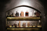 A rustic kitchen shelf filled with jars of homemade preserves and spice blends