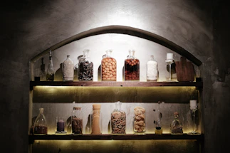 A welcoming wooden counter with jars of spices and bottles of edible oils softly lit for an inviting atmosphere.