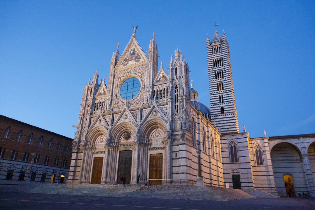 gray concrete church, Pic of the Siena cathedral taken at the sunset in a clear sky day. The rose window of the cathedra