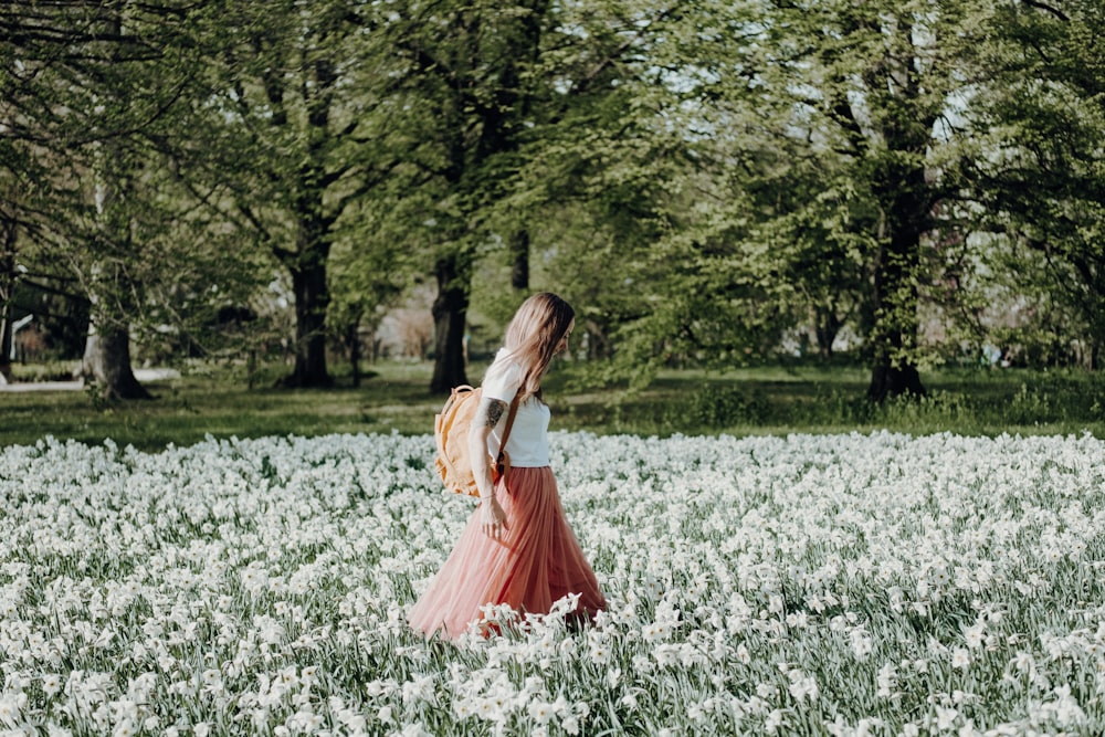 femme marchant sur un champ de fleurs