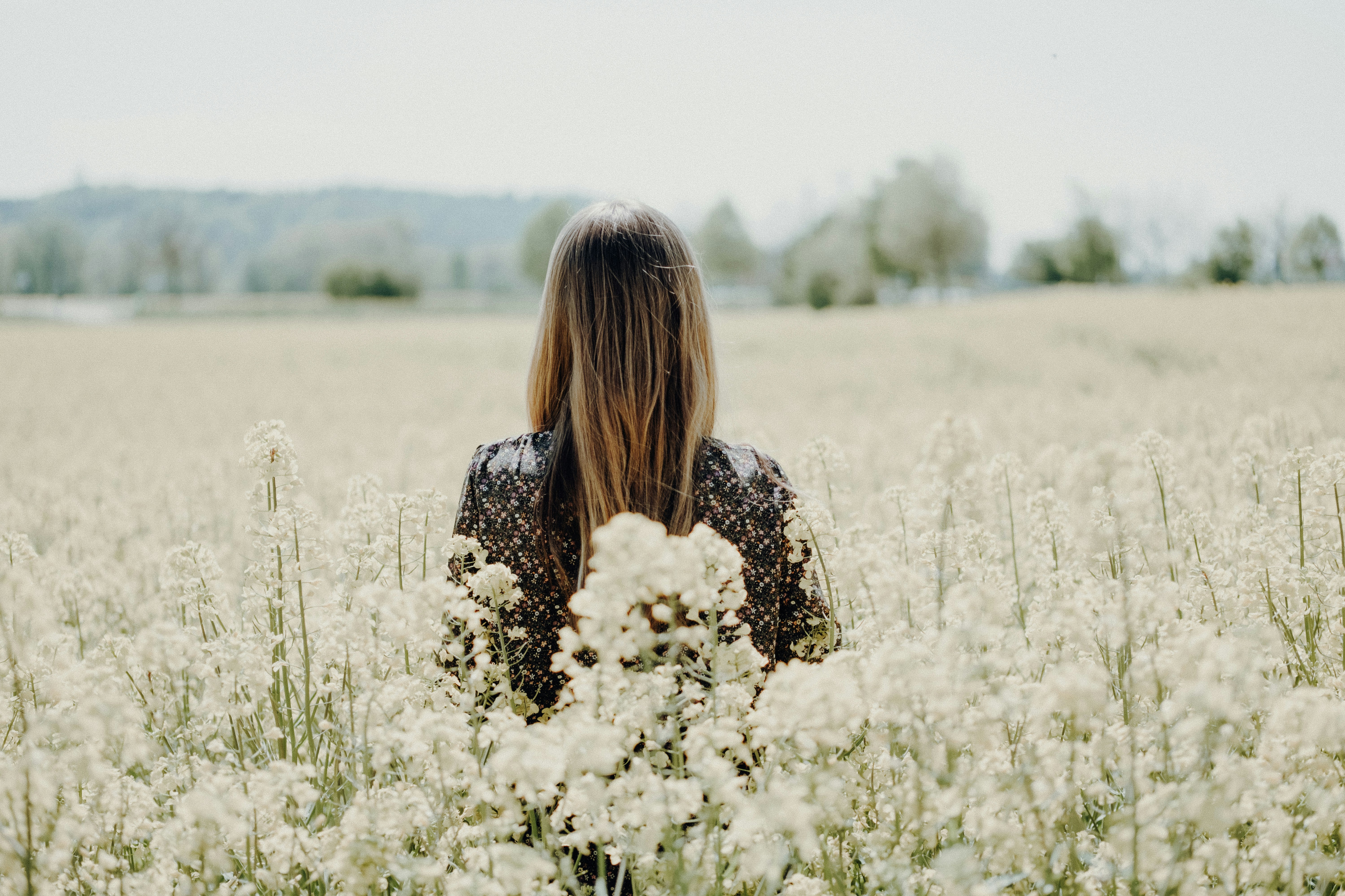 woman standing on white flower field