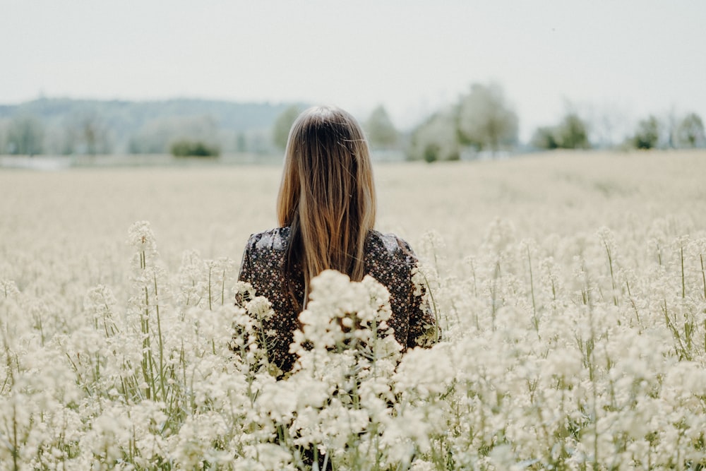 femme debout sur le champ de fleurs blanches