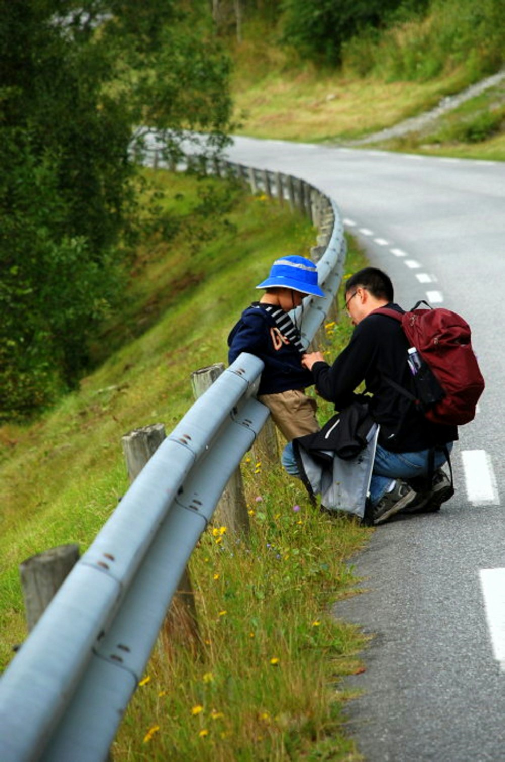 man taking care of toddler leaning on guardrail