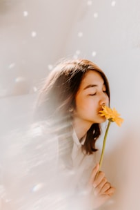 woman smelling on yellow flower