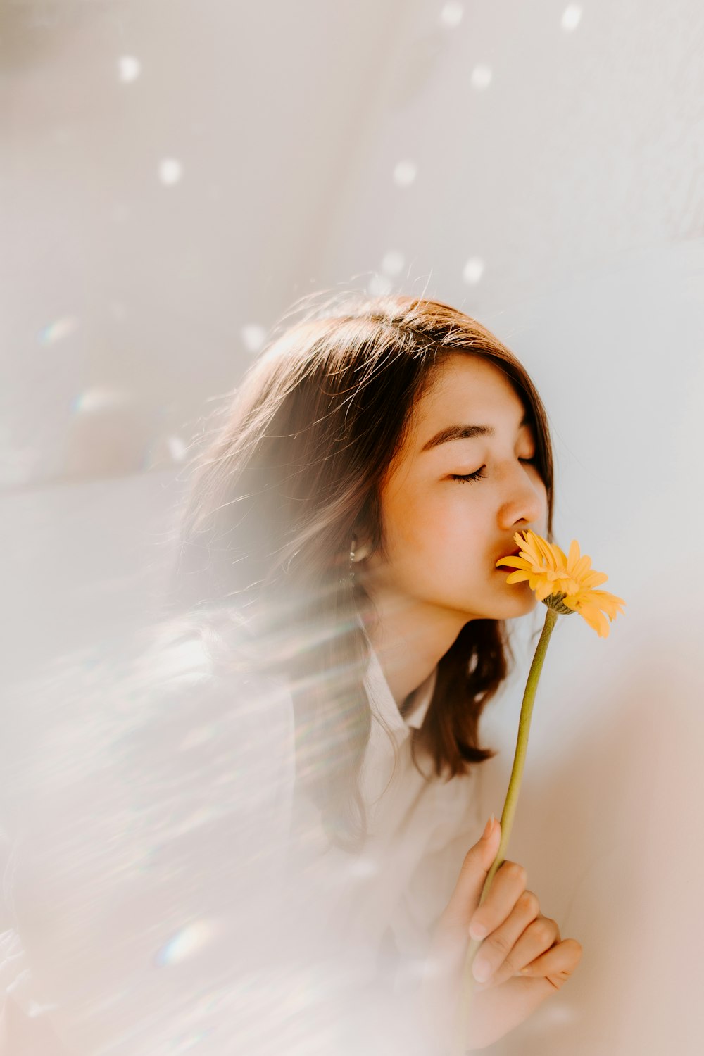 mulher cheirando na flor amarela