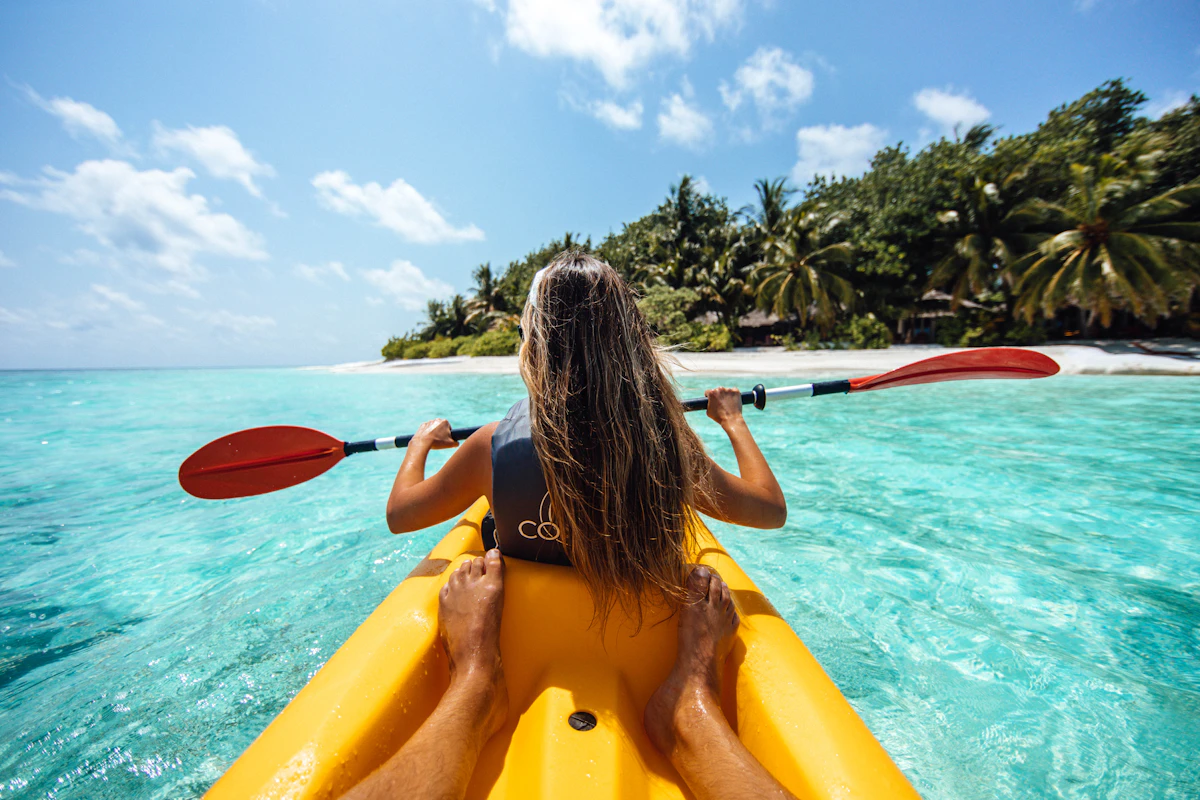 Person practicing kayak in the sea with views of the coast