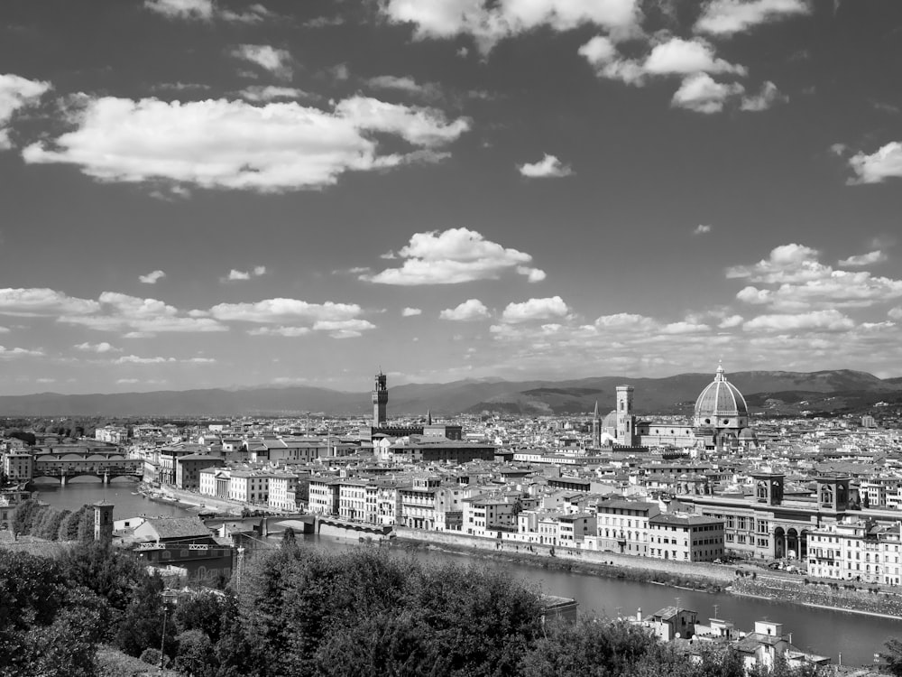 grayscale photography of city beside body of water