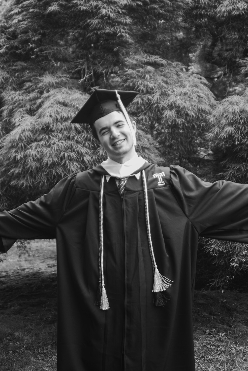 grayscale photography of man wearing academic dress