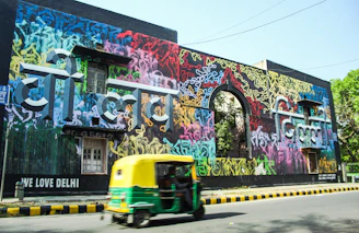 A vibrant Delhi neighborhood with a Maidful professional spraying pest control outside a home.