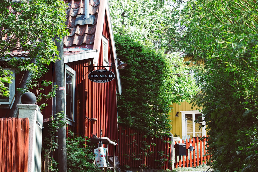 Casa de madera roja y amarilla rodeada de árboles