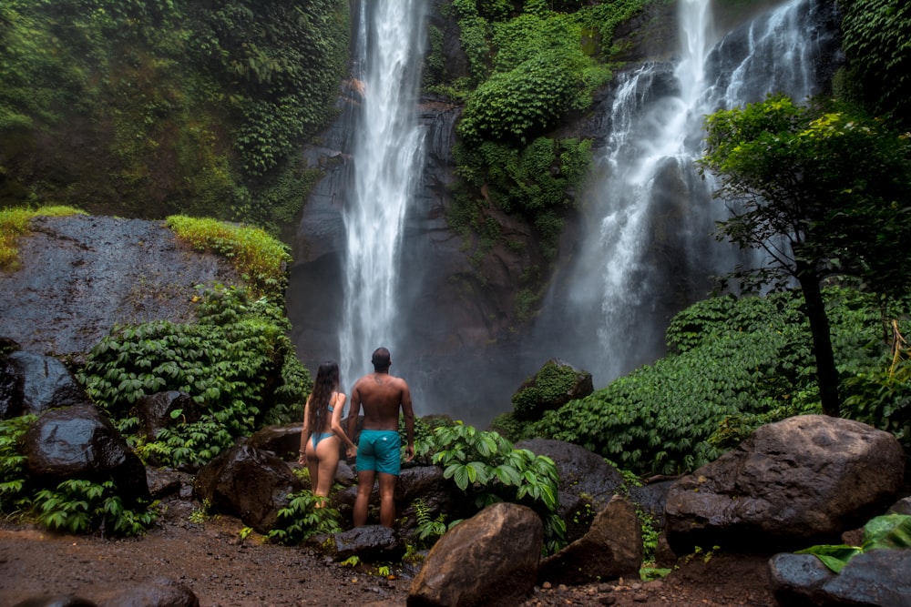 man and woman near waterfalls