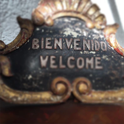 Colorful 3D printed lettering spelling 'Bienvenido' on a cozy living room wall.