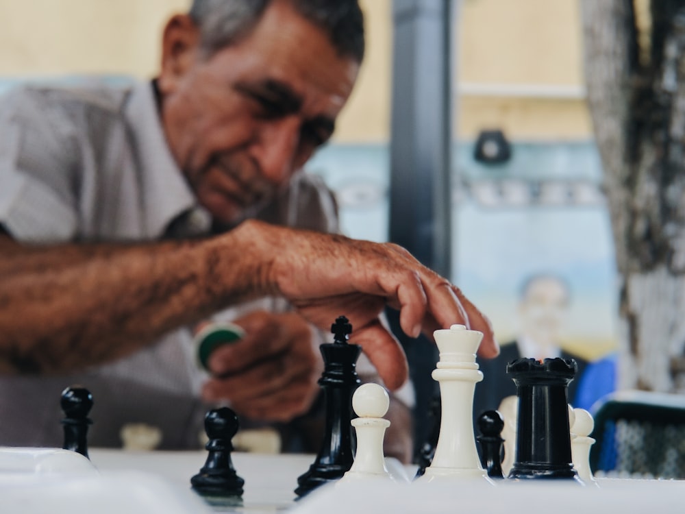 shallow focus photo of man playing chess