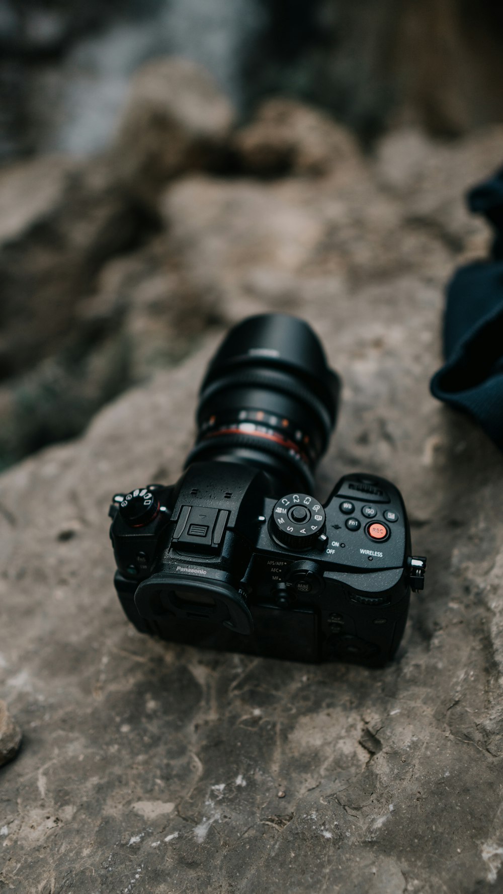 schwarze DSLR-Kamera auf braunem Felsen