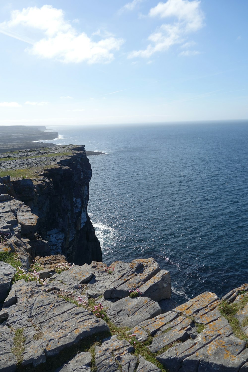 cliff near calm body of water during daytime