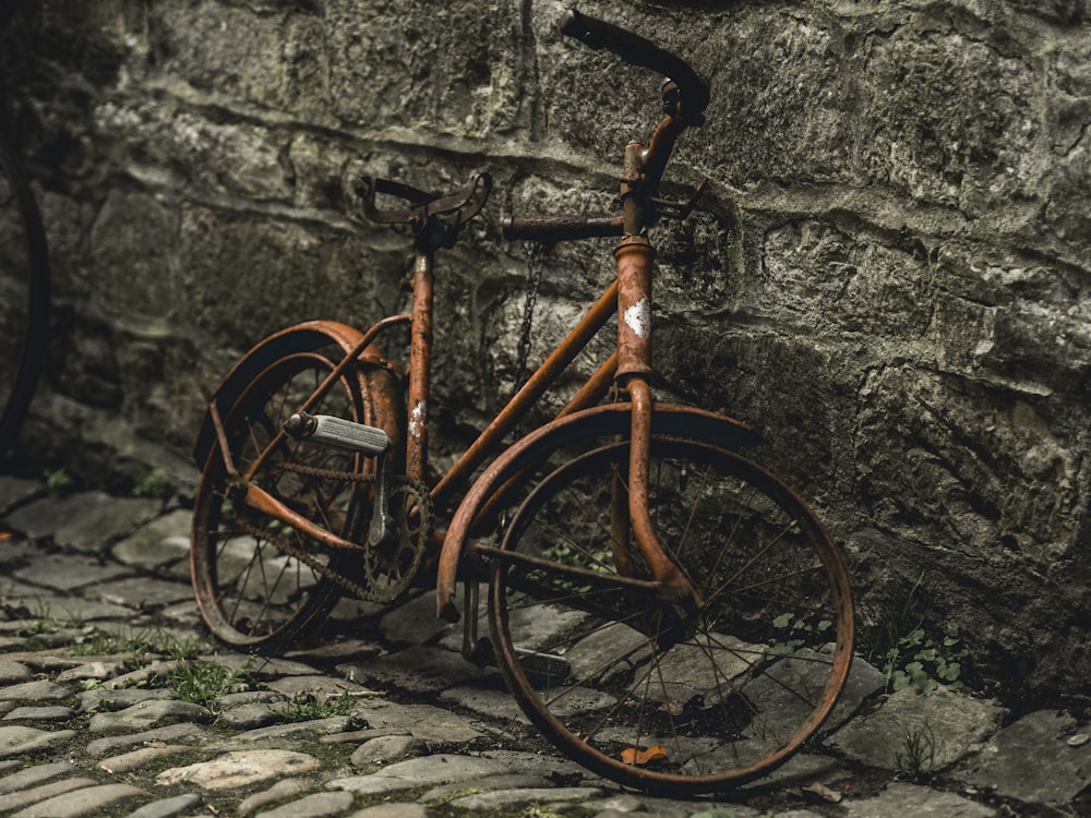 orange commuter bicycle parked on wall