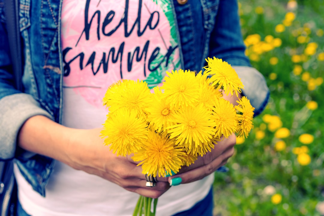 person holding yellow petaled flowers