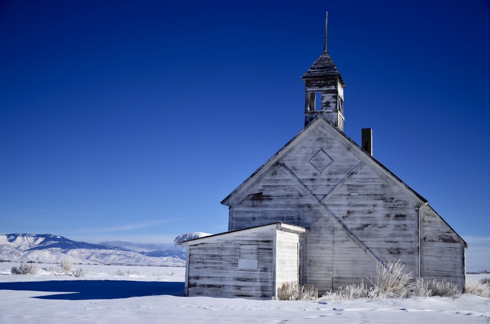 white wooden building on snow field during daytiime