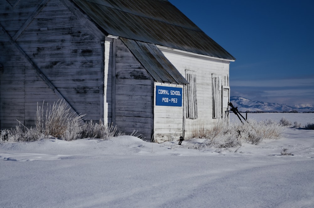 white and gray wooden house viewing field covered with snow