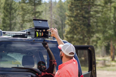 Driver checking the vehicle before a trip in a bright outdoor setting.