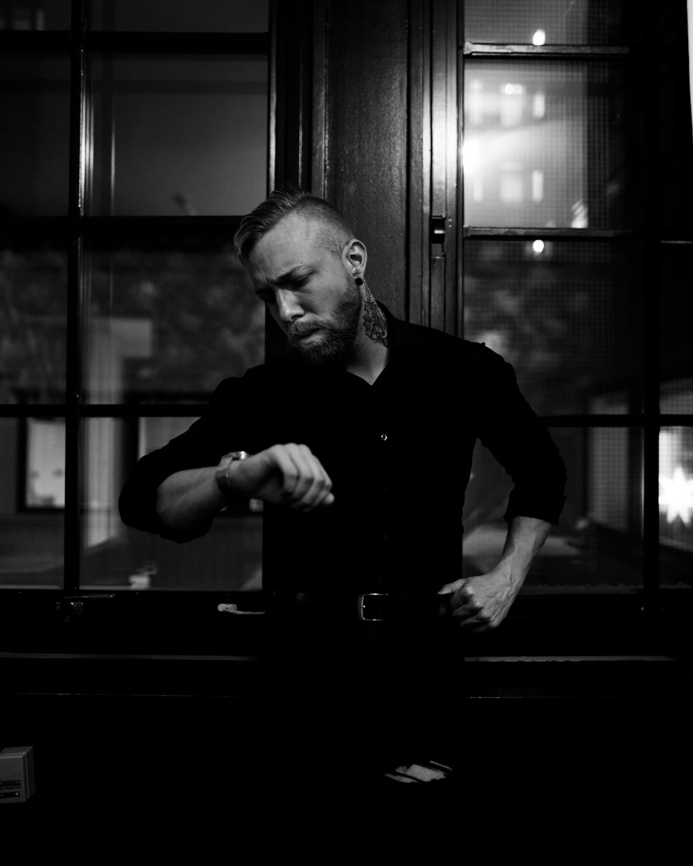 man in long-sleeved shirt looking at his watch