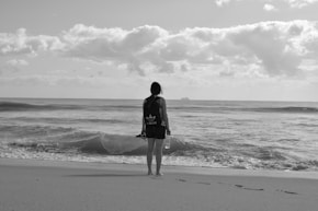 woman standing near seashore facing back