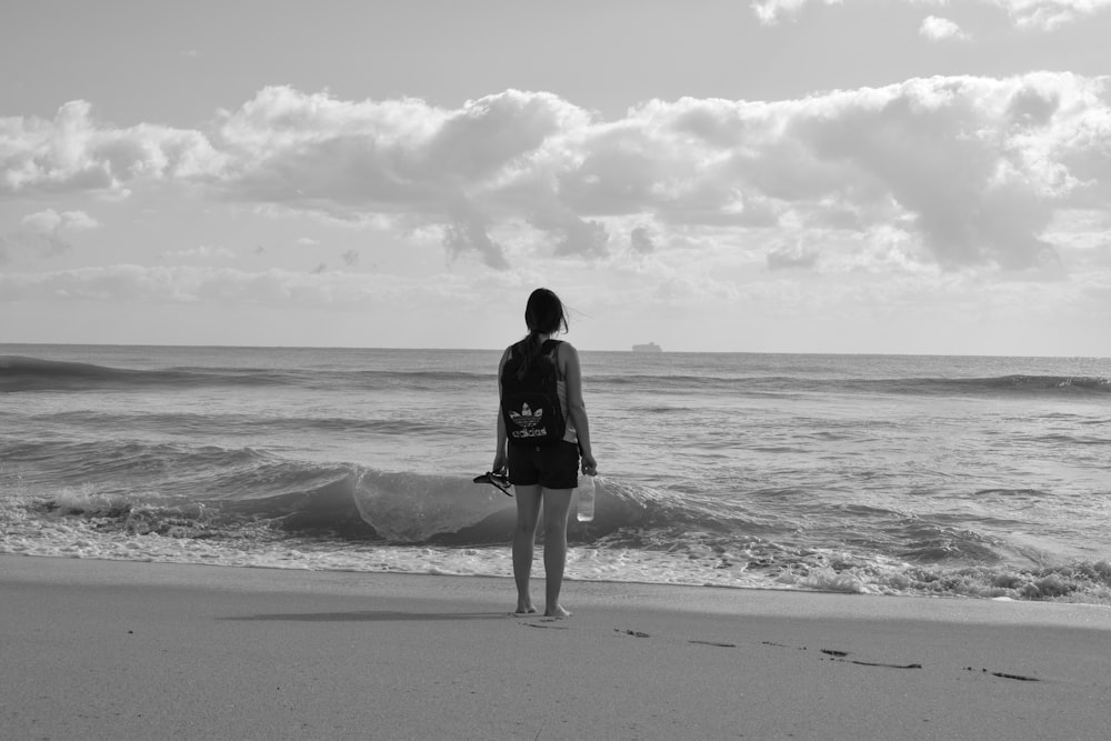 海岸のそばに後ろを向いて立っている女性