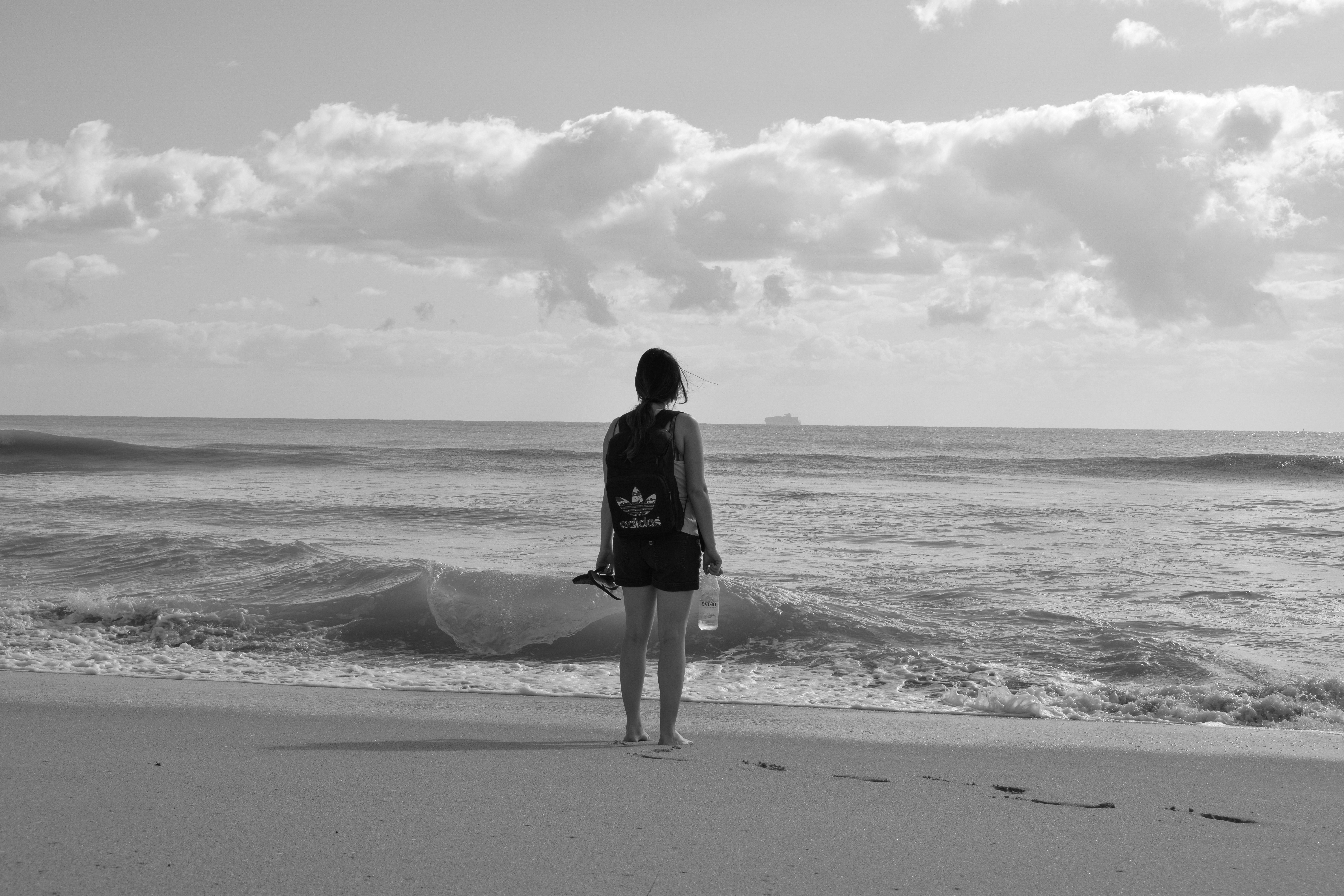 woman standing near seashore facing back