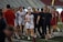 A group of female athletes on a sports field, with players wearing uniforms with 'Maryland' written on them. The scene appears to be after a match, with some players looking focused and others animatedly interacting. The setting is likely a stadium, evident by the stands in the background.
