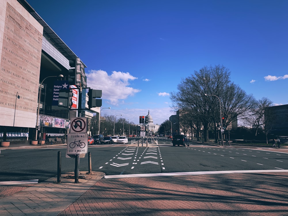 vehicles on road near buildings and tree