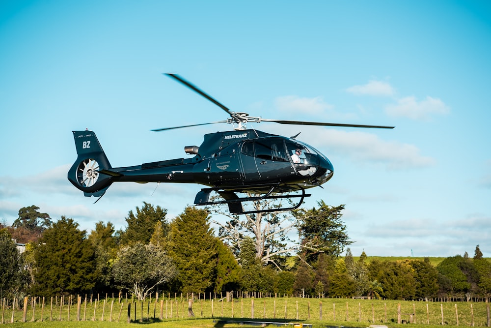 black helicopter near trees