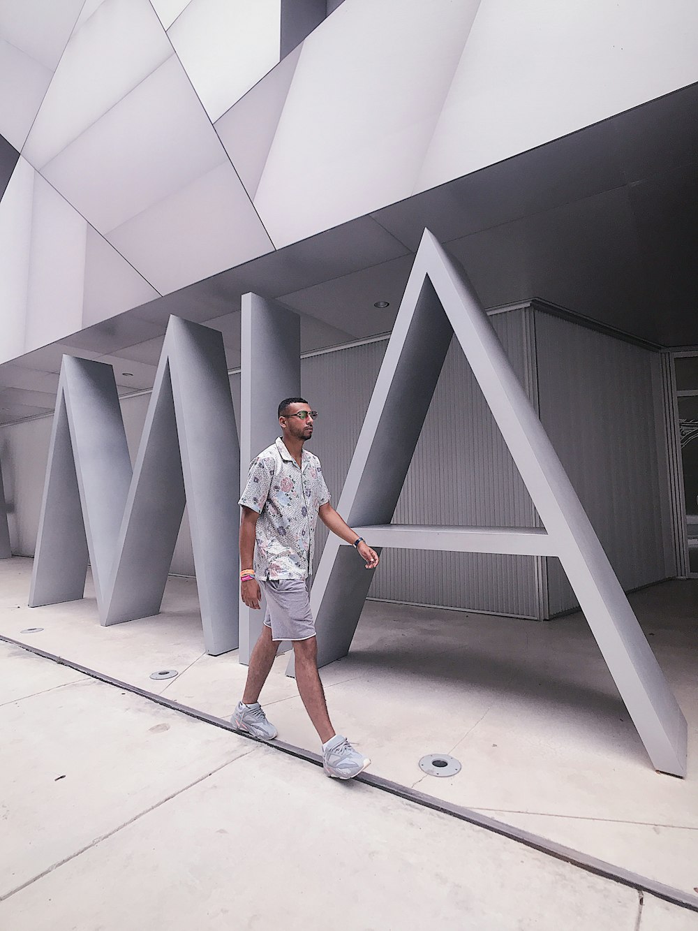 man walking beside white concrete building