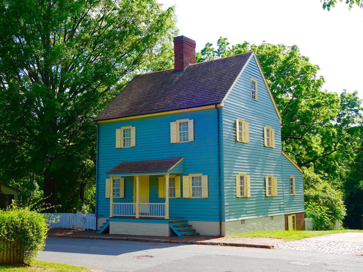 A blue colonial house with yellow trim