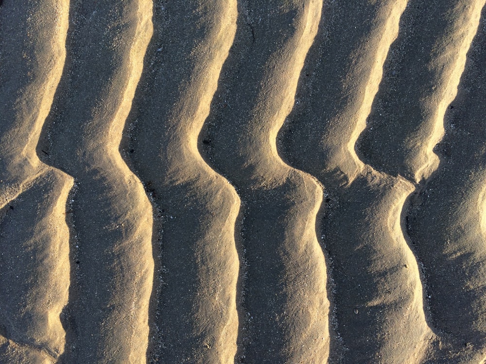 um close up de uma duna de areia com linhas onduladas