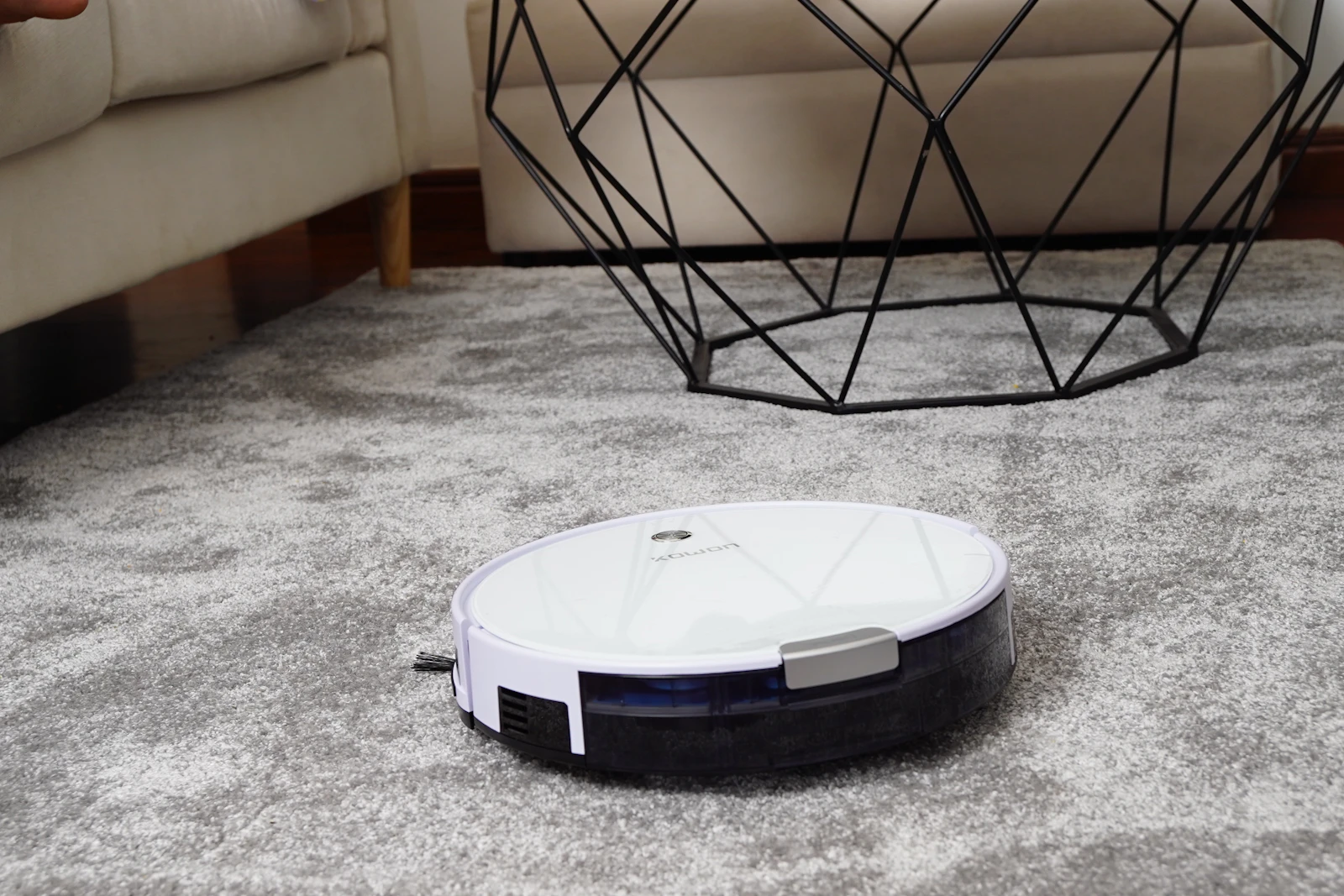 A robot vacuum working across a living-room rug