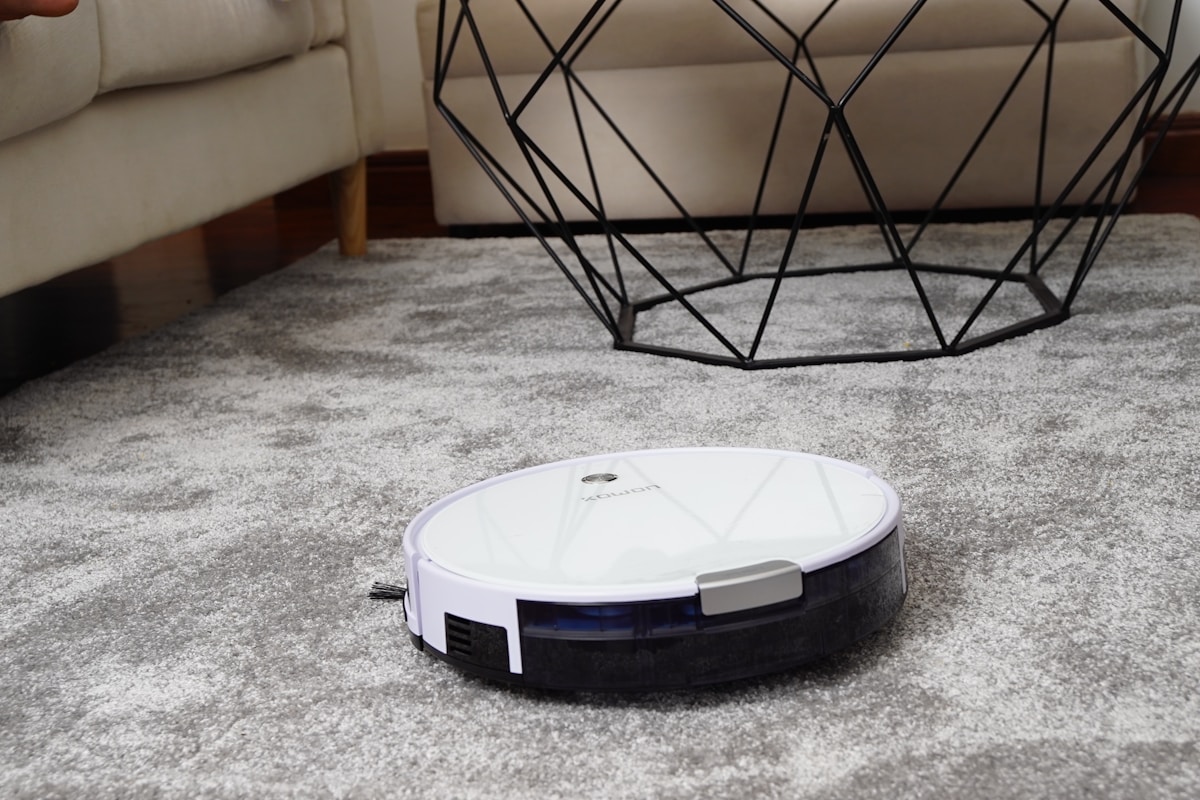 White robot vacuum cleaner on area rug