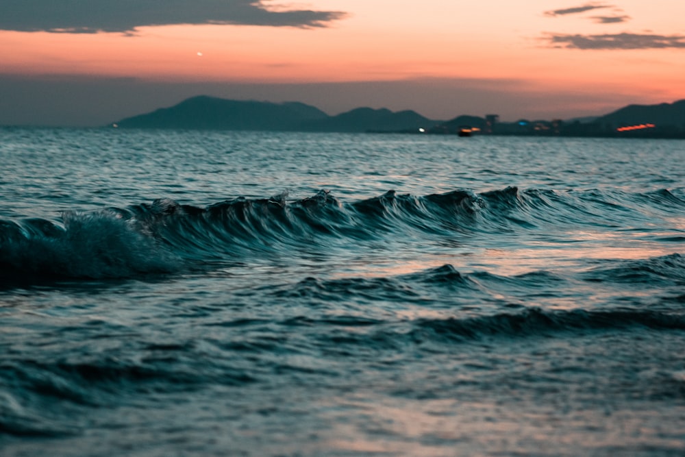 Die Welle rollt bei Sonnenuntergang ans Ufer