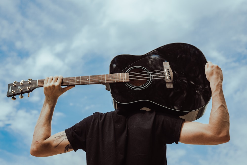 man holding acoustic guitar