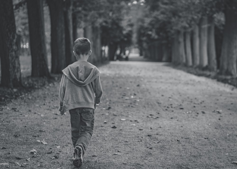 boy walking near trees