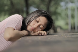 woman sleeping and leaning her face on pavement