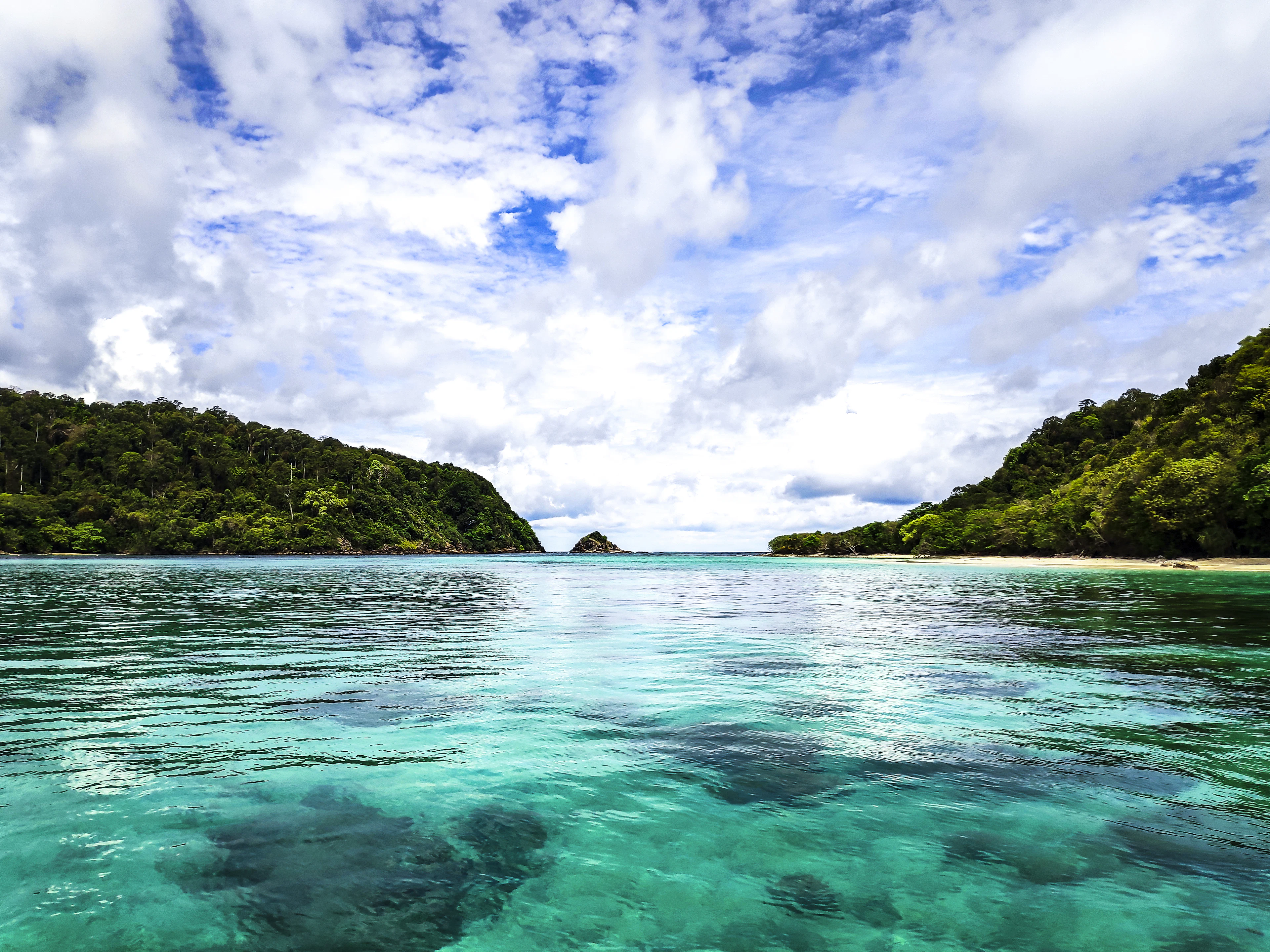 Clear turquoise water between the two forested islands of Koh Rok in the Andaman Sea