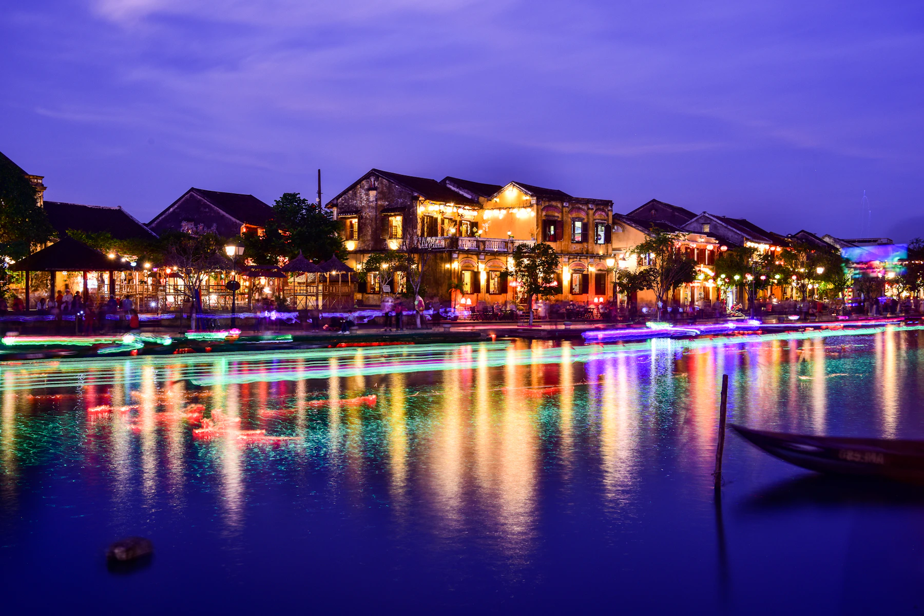 Hoi An's yellow riverfront buildings reflected in the Thu Bồn River after dark