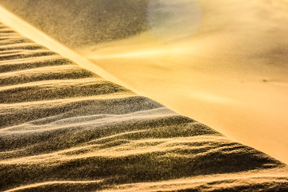 a person riding a snowboard on top of a sand dune