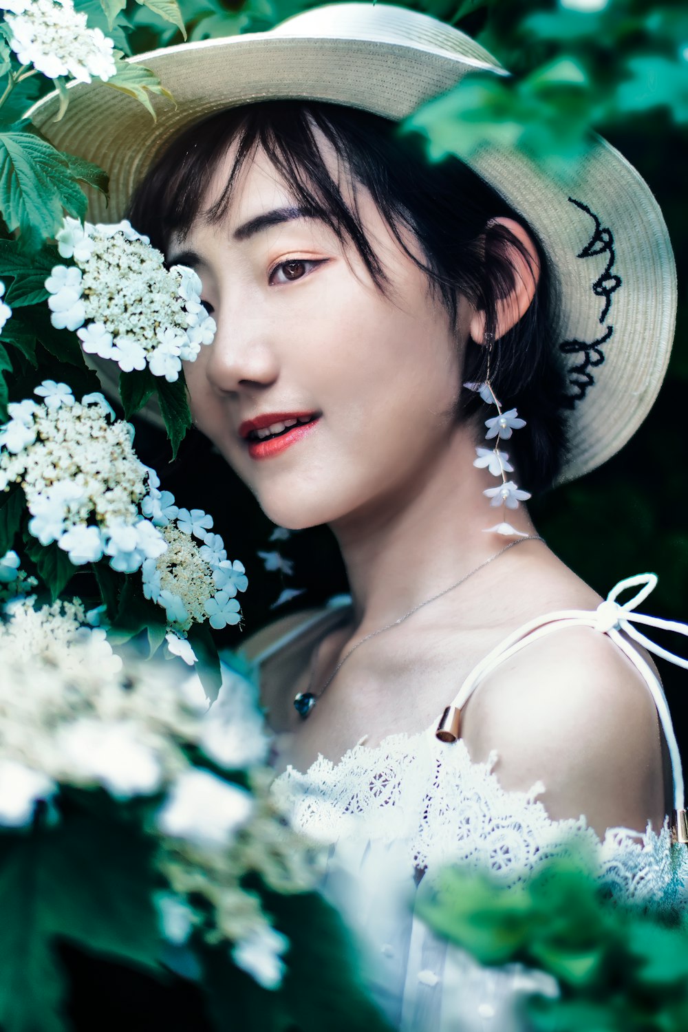 woman standing behind white-petaled flowering plant