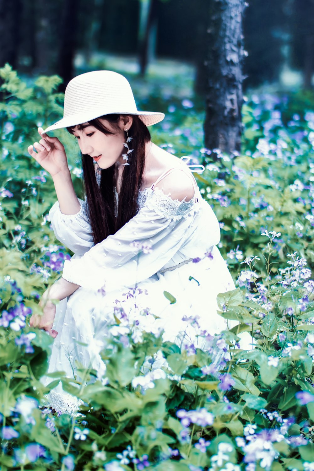 Mujer con sombrero y vestido rodeada de flores