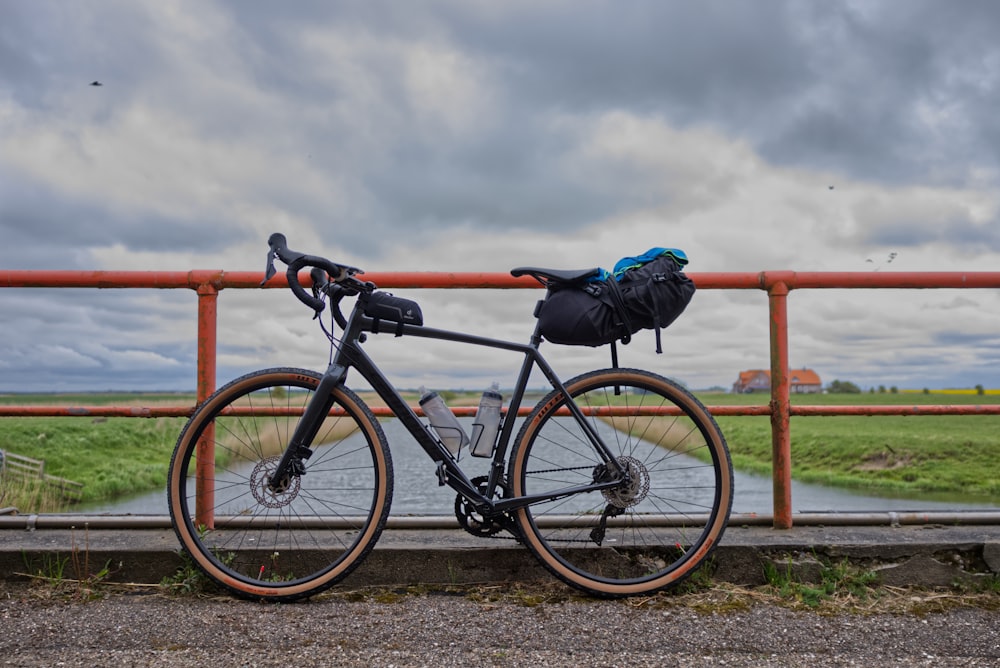 parked black bicycle beside handrail