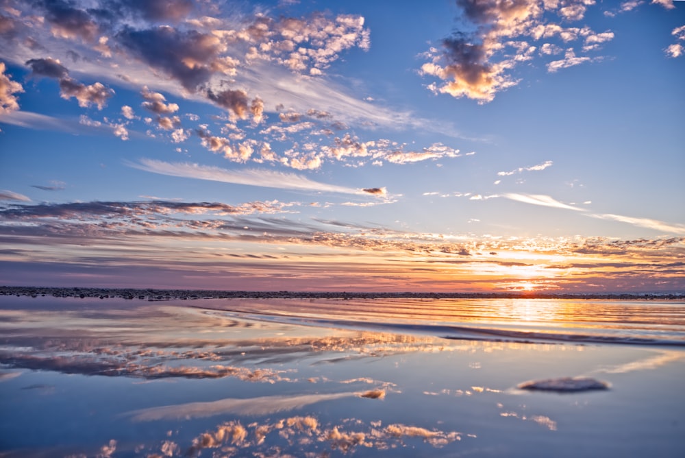 body of water under white and brown clouds