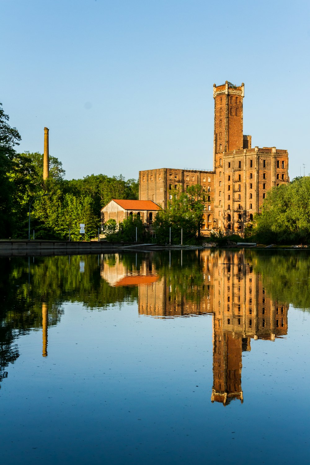 calm body of water near brown building during daytime